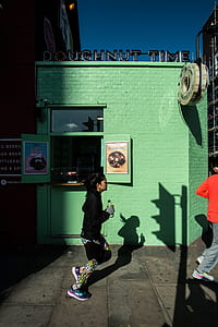 woman running on the street passing doughnut time store thumbnail
