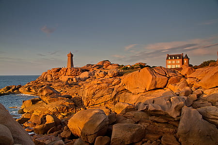 brown castle on rock beside ocean at daytime thumbnail