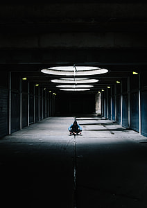 man sitting on gray concrete floor inside room thumbnail