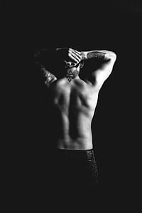 person with tattooed skin wearing black denim bottoms thumbnail
