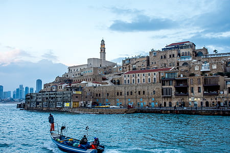 people on boat near brown buildings at daytime thumbnail