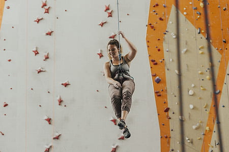 woman hanging on rope near mountain climbing wall thumbnail
