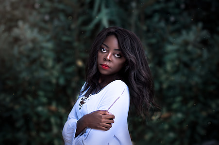 woman in white long-sleeved shirt holding her arm thumbnail