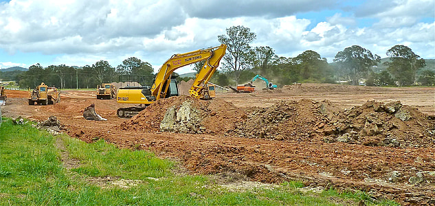 yellow excavator operating during daytime thumbnail