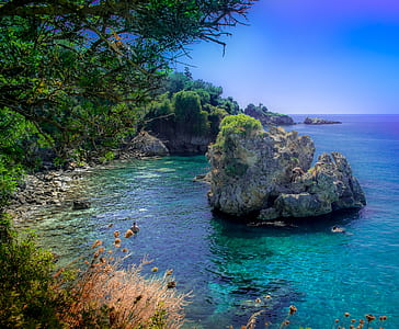 rock formation surrounded with body of water thumbnail