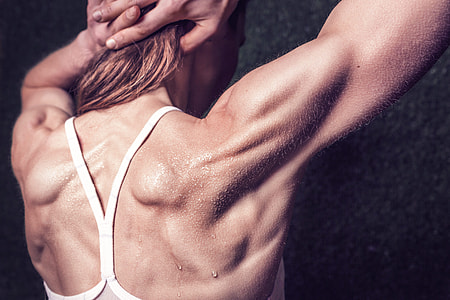 woman wearing white racerback tank top flexing muscle thumbnail