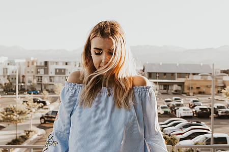 woman in white and blue pinstripe off-shoulder long-sleeved blouse on focus photo thumbnail