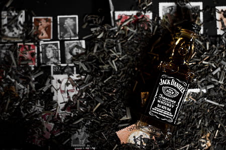 Jack Daniel's whisky bottle on postage stamps and metal tools thumbnail