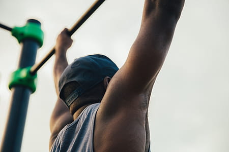 A young african man doing chin-up exercise outdoors thumbnail