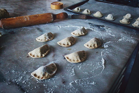 uncooked empanada on tray beside rolling pin thumbnail