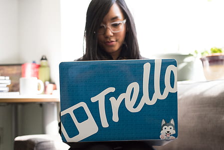 Woman Wearing Eyeglasses Using Blue and and Gray Laptop Inside Room thumbnail