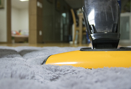 yellow and black upright vacuum on gray fleece rug inside room thumbnail