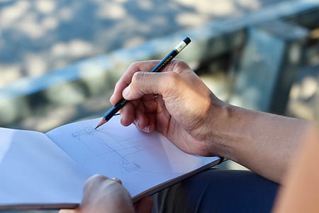 person writing on white open book thumbnail
