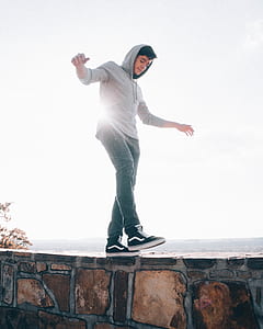 man walking on brown wall thumbnail