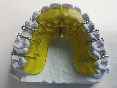 yellow and white teeth brace molder on white surface thumbnail