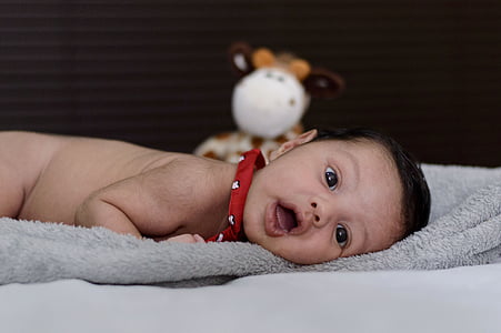 selective focus photography of baby lying on gray surface thumbnail