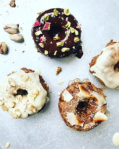 four spinkled and topped donuts thumbnail