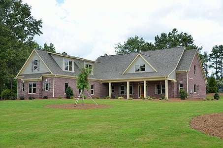 gray and beige house surrounded by green backyard thumbnail