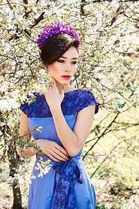 woman wearing blue floral lace short-sleeved dress and purple floral headpiece thumbnail