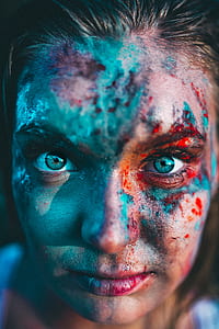woman with face covered in teal and red paint thumbnail