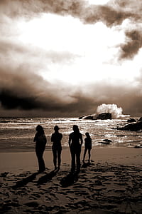 four people standing on shoreline photography thumbnail