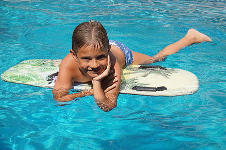 boy on surfboard floating on body of water thumbnail