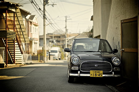 classic black vehicle parked on sidewalk near building thumbnail