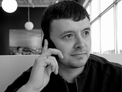 grayscale photography of man using his black smartphone thumbnail
