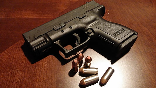 black semi-automatic pistol with bullets on table thumbnail