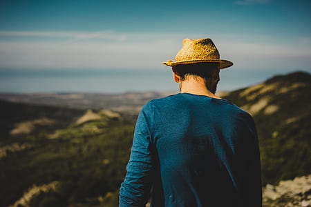 man on cliff under blue sky thumbnail