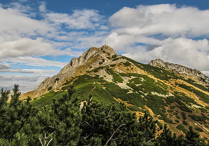 brown mountain under cloudy sky thumbnail
