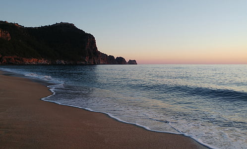 seashore and mountain during sunrise thumbnail