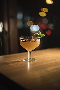 selective focus photography of footed cup with yellow liquid thumbnail