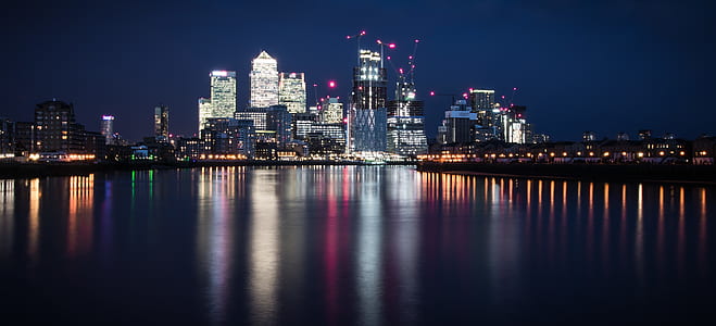 body of water near high-rise buildings at nighttime thumbnail