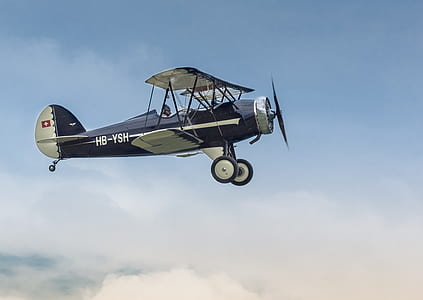 silver and blue biplane on sky thumbnail