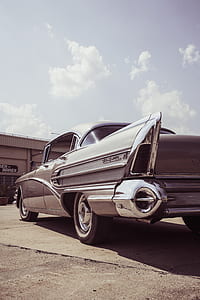 classic gray sedan under white sky thumbnail