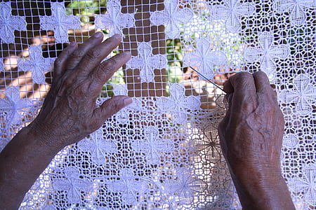 person holding white floral textile thumbnail