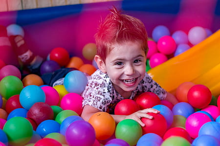toddler boy lying on ball pool thumbnail