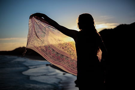 silhouette of woman holding brown shawl thumbnail
