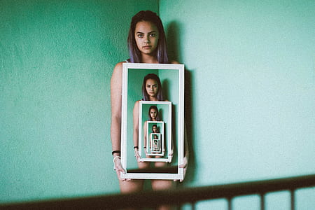 woman holding rectangular white frame thumbnail