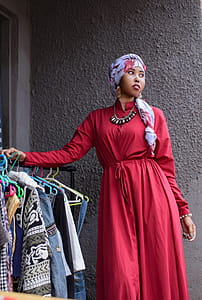 Woman Standing Near Black Metal Clothes Rack thumbnail