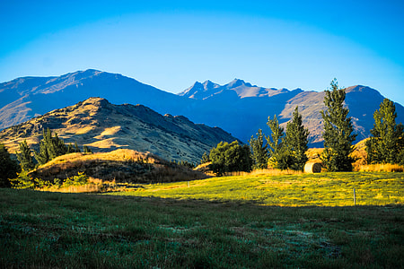 green field with mountain range during the daytime thumbnail