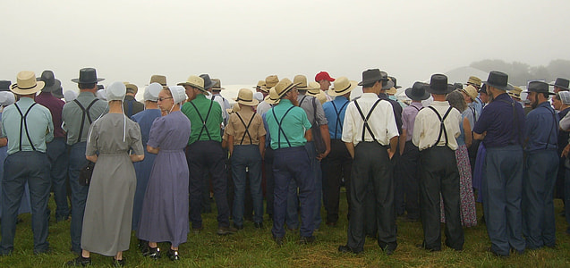 people standing under grey sky with hats thumbnail