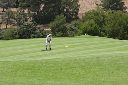 man playing golf on field thumbnail