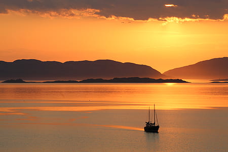 silhoutte of boat sailing on sea during dusk thumbnail