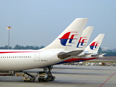 three white-and-red airplanes landing on ground thumbnail