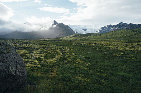 photography of green grass field under why sky near mountains thumbnail