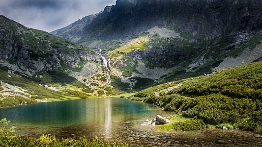 green mountain near body of water during daytime thumbnail