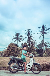 Boy Riding on White and Red Underbone Motorcycle thumbnail
