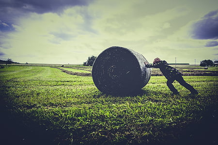 person pushing bale of hay thumbnail